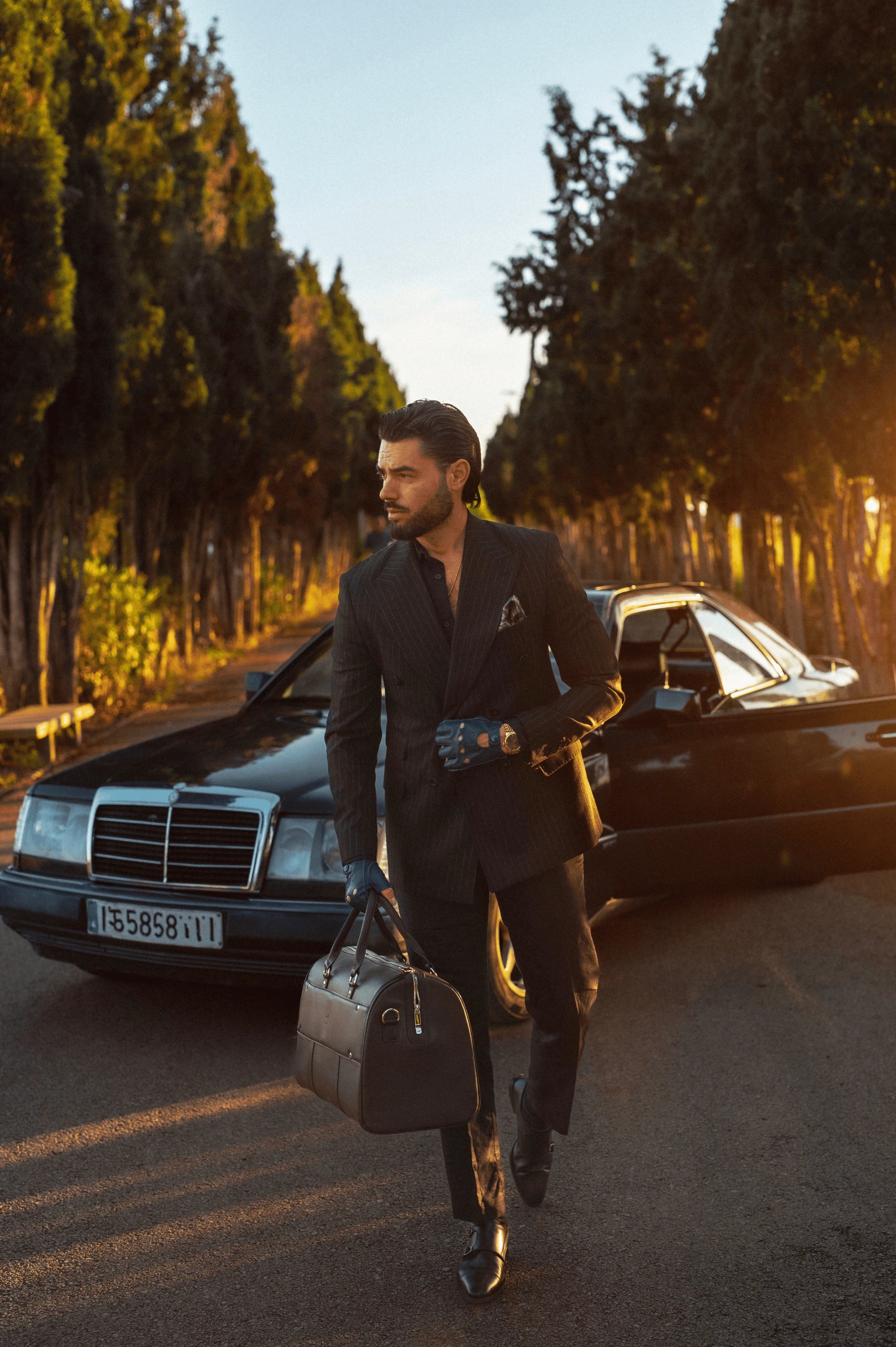 mitaines en cuir de luxe pour homme portées par Danielo Costa dans un style homme luxe travel lifestyle avec une mercedes noire neuve en fond