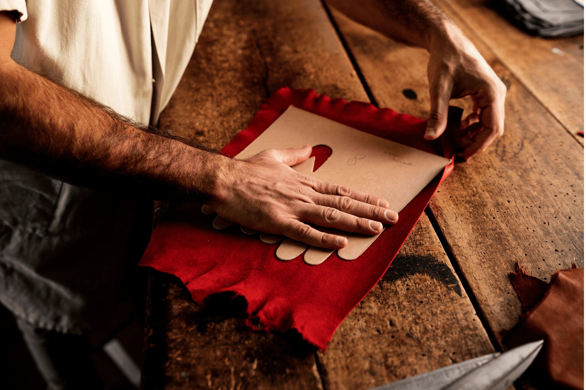 artisan du cuir confectionnant des gants de conduite qui place le patron de découpe