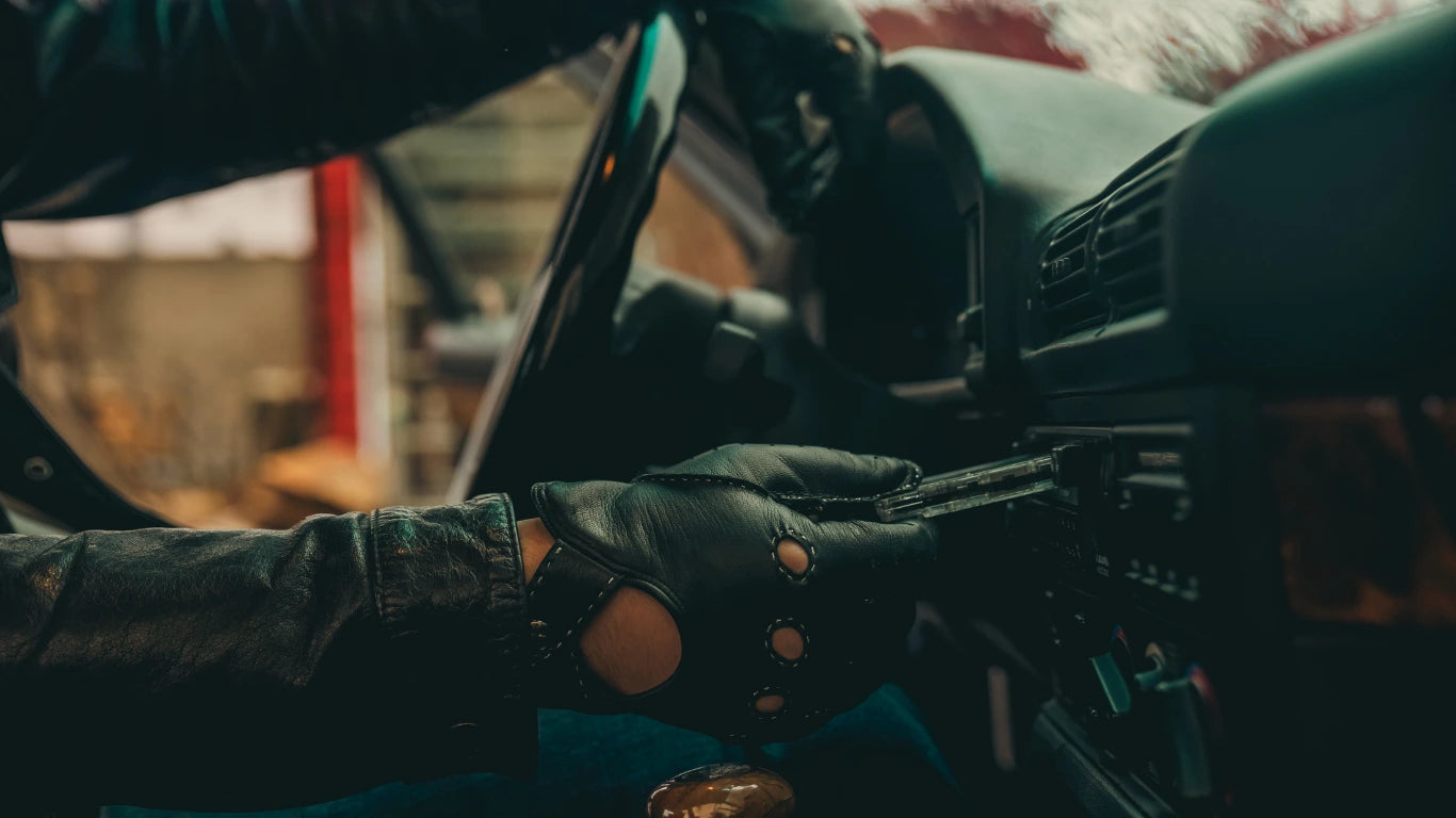 Gants de conduite personnalisés en cuir d'agneau vert oxford surpiqûres argent portés dans une BMW vert oxford par le bon tony tenant une cassette - La Main De l'Homme