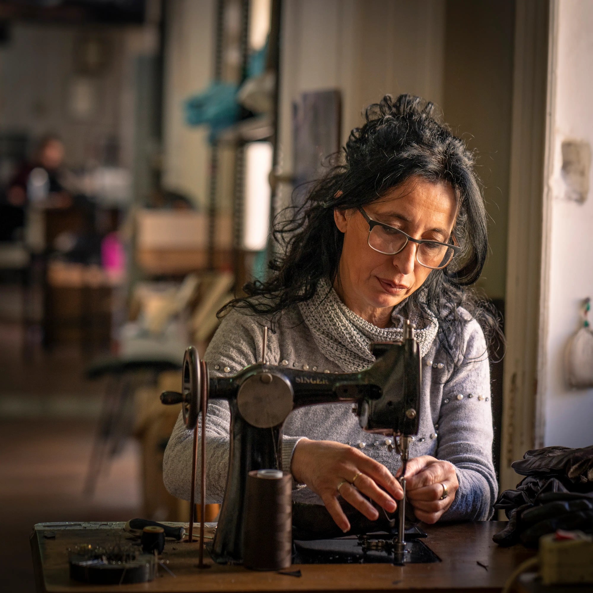 artisan couturière confectionnant des gants de conduite pour homme à la main 