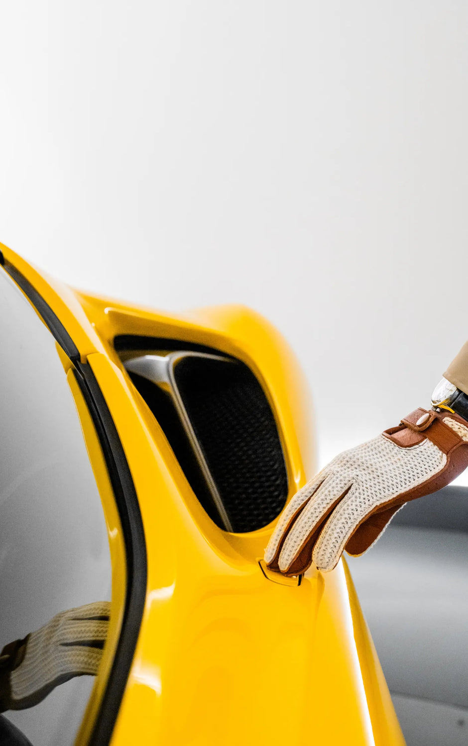 Gants de conduite Roadster en cuir de cerf camel et crochet blanc aux côtés d'une ferrari jaune portés par The Gloved Driver
